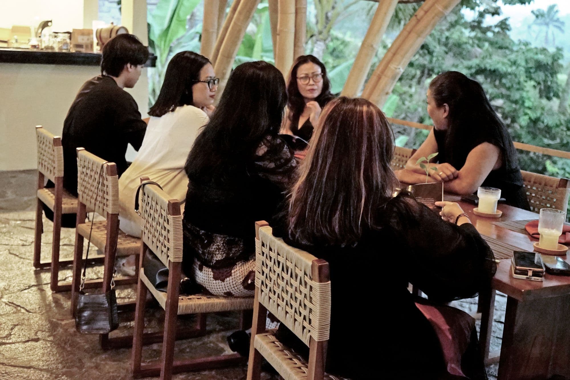 A long table gathering inside the bamboo dining hall